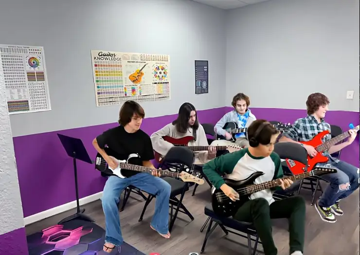 Students learning guitar in the VIP Studios classroom